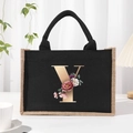 Black canvas tote bag featuring floral letter Y print with beige linen trim and rope handles - Bronze Floral Letter Y