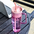 Pink large-capacity plastic straw cup with handle and Shak HANDS print on a wooden table - 40oz / Rose Red