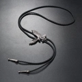 Detailansicht der Eagle-Bolo-Tie mit schwarzer Kordel auf einer strukturierten Oberfläche - Schwarzer Adler