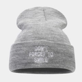 Close-up of grey ribbed knit beanie featuring white 'DON'T FORGET TO SMILE' embroidery - One Size / Light Gray