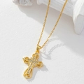 Close-up of gold-plated cross pendant with clear cubic zirconia on white stone - Gold/Hollow Zirconia Cross/I