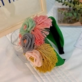 Close-up of handmade fabric floral headband with tassels and colorful mesh flower details - Green