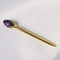 Macro detail van een gouden metalen balpen met een paarse kristallen edelsteen versiering - Droom Amethist
