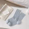 Light grey blue ribbed mid-calf socks with curled edges in a minimalist lifestyle setting - One Size / Blue