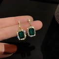 Close-up of geometric gold earrings with emerald green stones and sparkling pavé crystals - 16# Green Square Drop Earrings