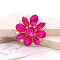 Detail shot of rose red crystal flower accessory with gold base on a textured stone surface - Rose Red