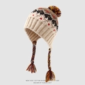 Close-up of Fair Isle knit kids hat with colorful braids and soft pom-pom detail - 3-8 Years / Beige