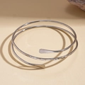 Detail of silver double-layered spiral cuff bracelet featuring a textured hammered finish - Silver