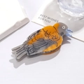 Detail of bird-shaped acetate hair claw clip with orange and grey feather patterns - Oriole