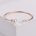 Minimalist rose gold open bangle featuring two elegant pearls on a geometric display - Rose Gold