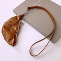 Detailed view of a brown faux leather croissant pouch necklace with metal zipper - Brown