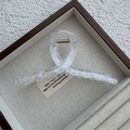 Close-up of a large transparent lace mesh hair claw clip with golden metal spring - Cross / White