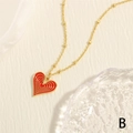 Detalle de un colgante de corazón rojo en una cadena de bolas dorada sobre tela suave - Rojo