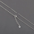 Macro detail of silver rhodium plated cross chain necklace with lobster clasp and bead - Silver O-Chain