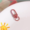 DIY rose gold metal lobster clasp with 360-degree swivel ring on white ceramic plate - Light Coffee Iridescent