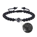 Detail eines mattschwarzen Perlenarmbands mit I Love You Projektion und gewebtem Band - Runder Anhänger - Mattstein