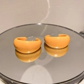 Macro view of glossy orange C-shaped resin earrings with silver needles on mirror - 925 Sterling Silver Pin C-Shape / Ginger Yellow