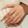 Macro detail of golden retro coin ring featuring Queen Elizabeth II relief on a hand - Gold Coin Relief Style (ALR042GL)