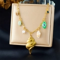 Gold ocean necklace featuring shell pendants, pearls and green stones on a display box - Conch Shell Style (N3538)
