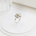Minimalistischer Gänseblümchen-Ring aus Edelstahl auf einem weißen Display-Podest - Größe 6 / Blumenring / Silber-Gold Mix