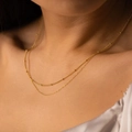 Double-layered gold snake chain necklace with beads on an elegant female model - Small Ball Chain Gold