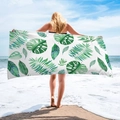 Scenic shot of a microfiber beach towel with green tropical leaf prints on white base - Green Palm