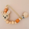 Handmade crochet bunny pacifier clip with natural wooden beads in light orange and beige - Khaki