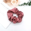 Detail of burgundy satin scrunchie with silky texture and folds on magazine prop - Dusty Pink