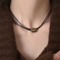 Gros plan d'un collier en œil de tigre brun avec des doubles cordons marron foncé - 7# Style Cordon Pierre Précieuse Ovale Argent