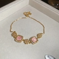 Detail of adjustable 18k gold plated bracelet with pink gems and floral accents - Pink Cat Eye Stone Style / Pink