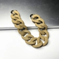 Detail of matte beige acrylic bag chain with gold metal rings on a neutral background - Khaki