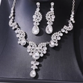 Details van luxe bruidssieraden met kristallen ketting en druppelvormige oorbellen - Ketting en oorbellen set / Zilver/Wit