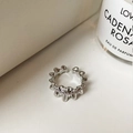Detalle macro de anillo ondulado de doble capa en plata con circonitas y diseño abierto - Plateado