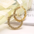 Luxuriöse vergoldete Creolen mit Zirkonia, kunstvoll neben einem Parfümflakon arrangiert - Geometrischer Hoop/Dreieck / Gold