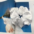 Detailaufnahme eines großen weißen Satin-Haargummis mit weicher seidiger Textur - 20cm / Weiß