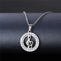 Macro detail of silver musical note necklace with sparkling pavé diamonds on grey background - NZ8 Treble Clef