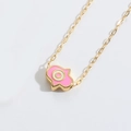 Makro-Detail des goldenen Hamsa-Handanhängers mit rosa Emaille und Augen-Design - Rosa (ES2815-3)