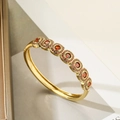 Dettaglio del bracciale dorato con sette pietre rosse tonde e accenti di zirconi - Tondo Rosso
