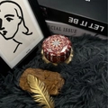 Handmade scented candle in red mandala tin container on luxury textured background - H13 Goji & Tarocco Orange