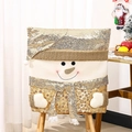 Detail of Christmas snowman chair cover with golden sequins and plush fabric on wood chair - Snowman