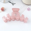 Pink matte wavy hair claw clip on a minimalist background with decorative dry flowers - Pink
