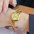 Women's gold quartz watch with irregular hollow link bracelet and square dial on wrist - Gold