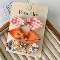 Set of 3 fabric bow hair clips with floral, checkered, and solid orange patterns - Orange Series