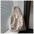 Detail of strawberry print on off-white corduroy tote bag showing rich fabric texture - White