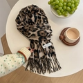 Sciarpa classica in cashmere leopardato con nappe ed etichetta 100% cashmere su tavolo bianco - Cachi
