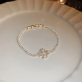 Vista macro del bracciale placcato oro con ciondolo a quadrifoglio e cristalli di zircone - Oro (Placcato Oro Vero)