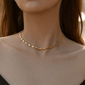 Collana minimalista in ottone placcato oro 18K indossata da una modella alla luce - Oro 18K