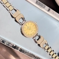 Gros plan d'une montre de luxe pour femme avec lunette en strass et cadran quartz doré - Boîtier Bicolore Cadran Doré
