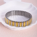 Elastic stainless steel bracelet in silver and gold tones on a shell-shaped dish - 12mm