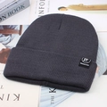 Close-up of dark grey ribbed knit beanie with TF CLASSIC label on magazine background - Grey (TF Label)